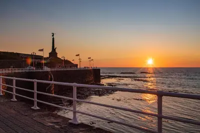 a sunset over the ocean with the statue of liberty at 1 Bed in Aberystwyth oc-bow285 in Aberystwyth