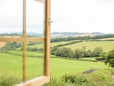 an open window with a view of a green field at Callow Fold in Craven Arms