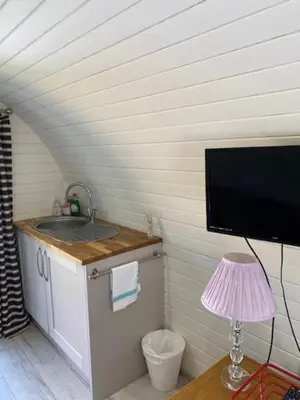 a small kitchen with a sink and a flat screen tv at The Pod in Aberystwyth