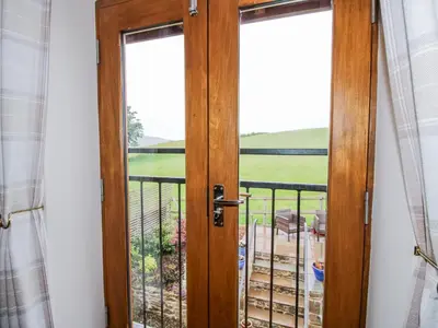 a door leading to a balcony with a view at Meadow Barn in Craven Arms