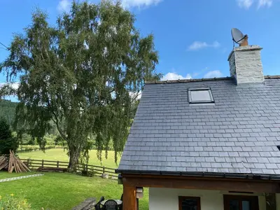 a roof of a house with a tree and a field at Tan Y Garth Cottage in Corwen