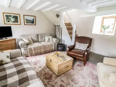 a living room with a couch and a chair at Tan Y Garth Cottage in Corwen