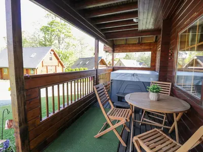 a screened in porch with a table and chairs at Sun View Lodge in Llanbedr