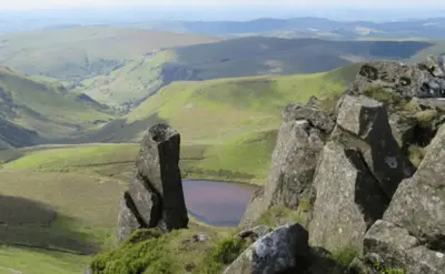a view from the top of a mountain with a lake at Wild Valley Bunkhouse in Llanrhaeadr-ym-Mochnant