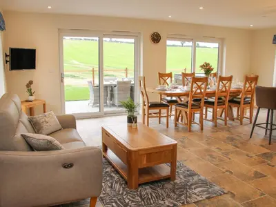 a living room with a couch and a table and chairs at Holly Lodge in Welshpool