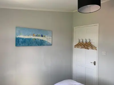 a bedroom with a painting on the wall next to a door at Modern Funky Private Chalet at the Beach in Tywyn