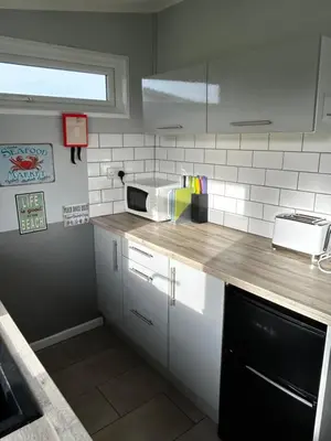 a kitchen with a counter top with a microwave at Modern Funky Private Chalet at the Beach in Tywyn