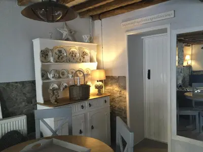 a dining room with a table and a shelf with plates at bwthyn y porthmyn in Llandovery