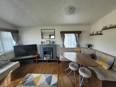 a living room with a couch and a table at Gloria Stay - Aberystwyth Caravan in Aberystwyth