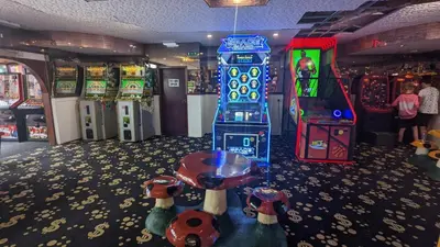 a gaming room with a video game system and machines at Gloria Stay - Aberystwyth Caravan in Aberystwyth