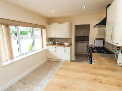 a kitchen with white cabinets and a large window at Awel Y Berwyn in Oswestry