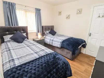 a bedroom with two beds and a couch at Awel Y Berwyn in Oswestry