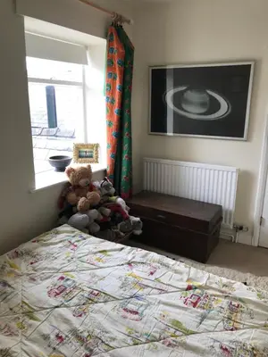 a bedroom with a bed with teddy bears and a window at Half Moon House top flat in Hay-on-Wye