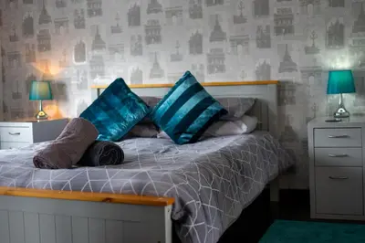 a bedroom with a bed with blue pillows at The Old Post Office in Llandrindod Wells