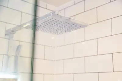 a shower in a bathroom with white tiles at Shrewsbury apartments by BEVOLVE - Free Parking in Shrewsbury