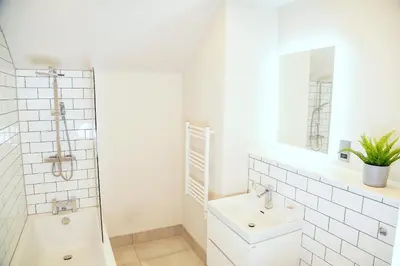 a white bathroom with a sink and a mirror at Shrewsbury apartments by BEVOLVE - Free Parking in Shrewsbury