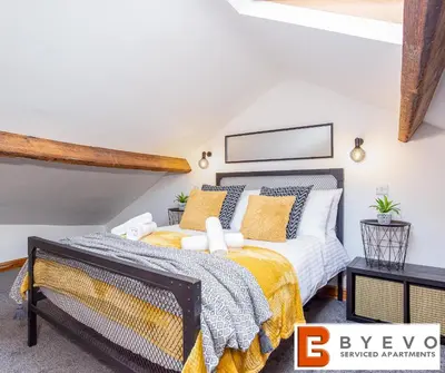 a bedroom with a king sized bed with yellow and white pillows at ByEvo Oswestry Barn - Quirky romantic retreat or Cosy contractor base in Oswestry
