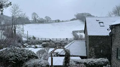 a house covered in snow next to a field at The Granary in Llanddeiniol