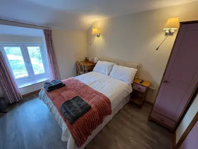 a hotel room with a bed and a window at The Star Inn in Dylife