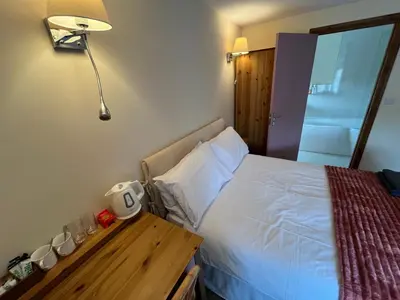 a bedroom with a bed and a table with a lamp at The Star Inn in Dylife