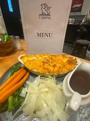 a plate of food with vegetables and a pizza at Y Griffin in Penrhyndeudreath