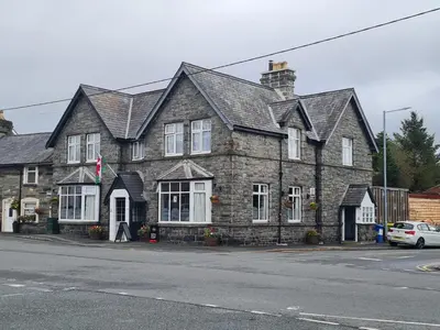 an old stone house on the corner of a street at Y Griffin in Penrhyndeudreath