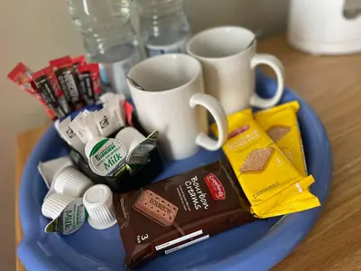 a blue plate with coffee cups and other items on it at Y Griffin in Penrhyndeudreath