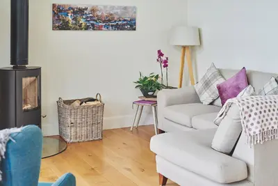 a living room with a couch and a fire place at Lower Tumble Cottage in Llandyssil