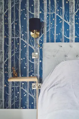 a bedroom with a bed and a blue forest wallpaper at Shepherds Rest in Llandyssil