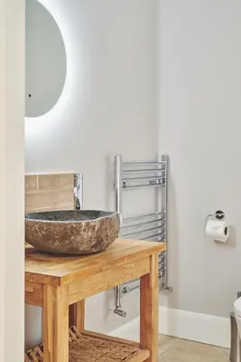 a bathroom with a stone sink on a wooden table at Shepherds Rest in Llandyssil