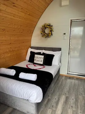 a bedroom with a bed with a happy thanksgiving pillow at The Midi Pod in Aberystwyth