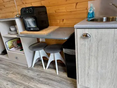 a kitchen with a counter with stools and a microwave at The Midi Pod in Aberystwyth