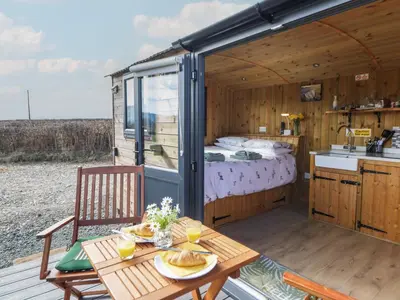 a caravan with a bed and a table with food on it at Claerwen in Llandrindod Wells