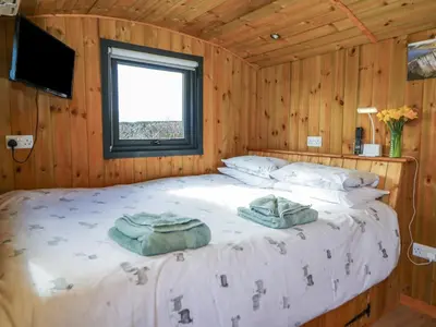 a bedroom with a bed with two towels on it at Claerwen in Llandrindod Wells