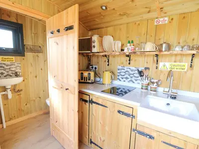 a kitchen with a sink and a stove in a cabin at Elan in Llandrindod Wells
