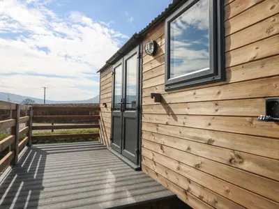 a wooden house with a deck and a window at Elan in Llandrindod Wells