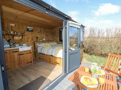 a caravan with a bed and a patio with a table at Elan in Llandrindod Wells