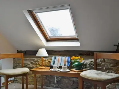 a room with a table with two chairs and a window at Stable Cottage in Leintwardine