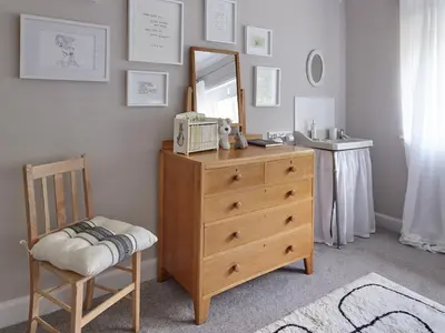 a bedroom with a dresser and a mirror and a chair at Green Acres in Llangollen