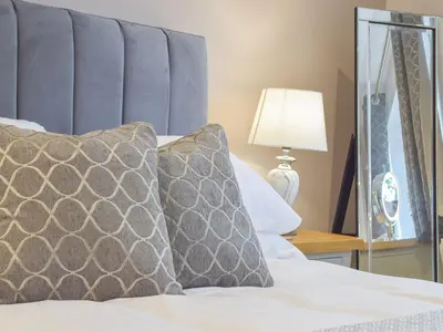 a bed with two pillows on it with a mirror at Llain Cottage in Llanina