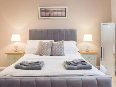 a bedroom with a large bed with two lamps at Llain Cottage in Llanina