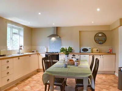 a kitchen with a table and chairs in a kitchen at Lower Farm in Llanfihangel Rhydithon