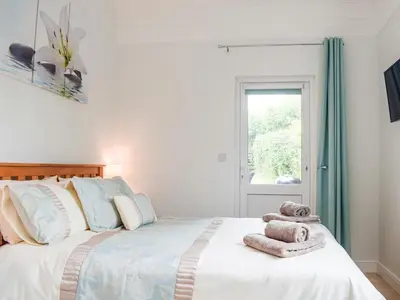 a bedroom with a bed with towels on it at The Lodge At Forbury Cottage in Kimbolton