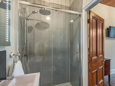a bathroom with a shower with a glass door at Groudd Hall in Cerrigydrudion