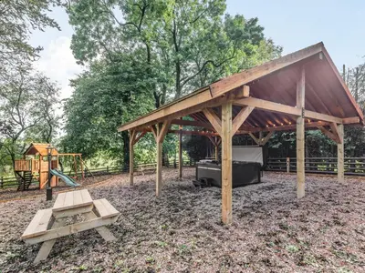 a pavilion with a picnic table and a playground at Groudd Hall in Cerrigydrudion