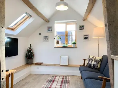 a living room with a window and a blue couch at The Granary in Clee Saint Margaret