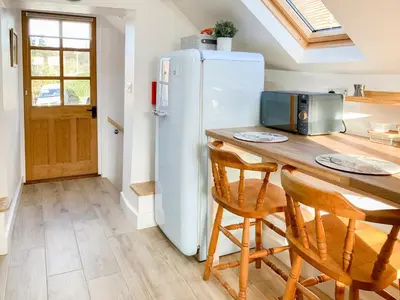 a kitchen with a refrigerator and a table with chairs at The Granary in Clee Saint Margaret