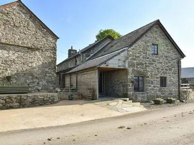 an old stone building with a large doorway at Stabal Rhoswen in Ffestiniog