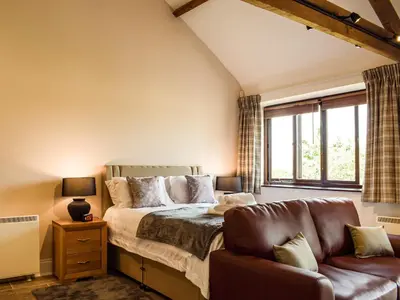 a bedroom with a bed and a couch at Hop Kiln Barn in Staunton on Wye