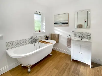 a white bathroom with a tub and a sink at Rose Cottage in Blakemere